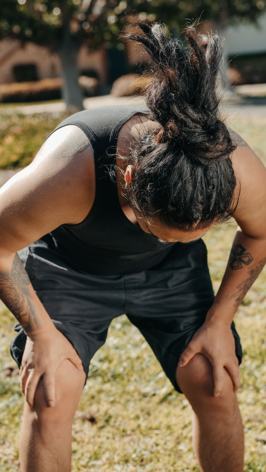 Runner pausing outdoors with hands on knees
